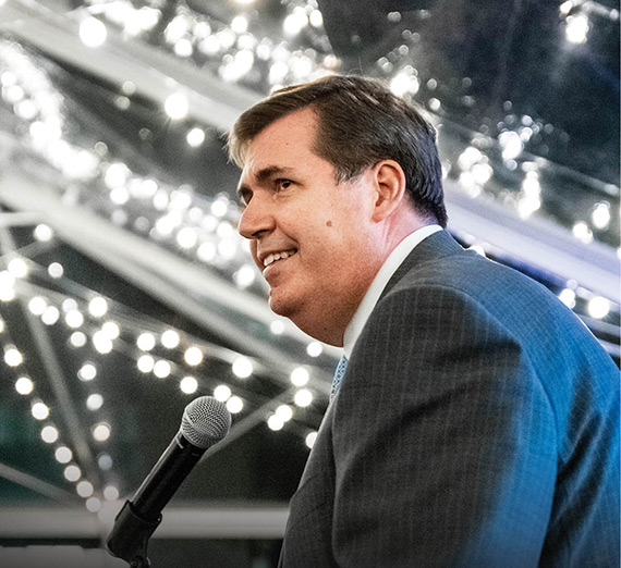 President McCulloh giving a speech with sparkling lights in the background.
