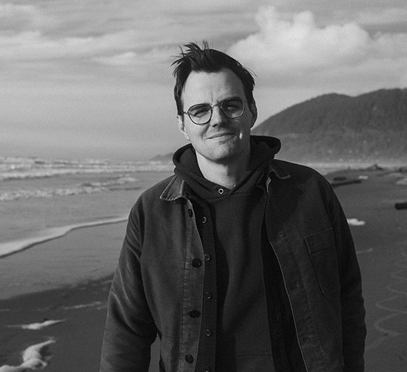 Jeff Rutherford looks at the camera as he stands on a beach