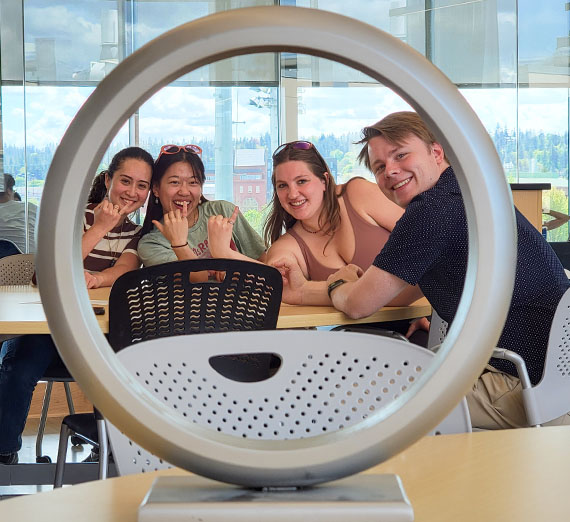 Four students show Order of the Engineer rings through the ceremony ring